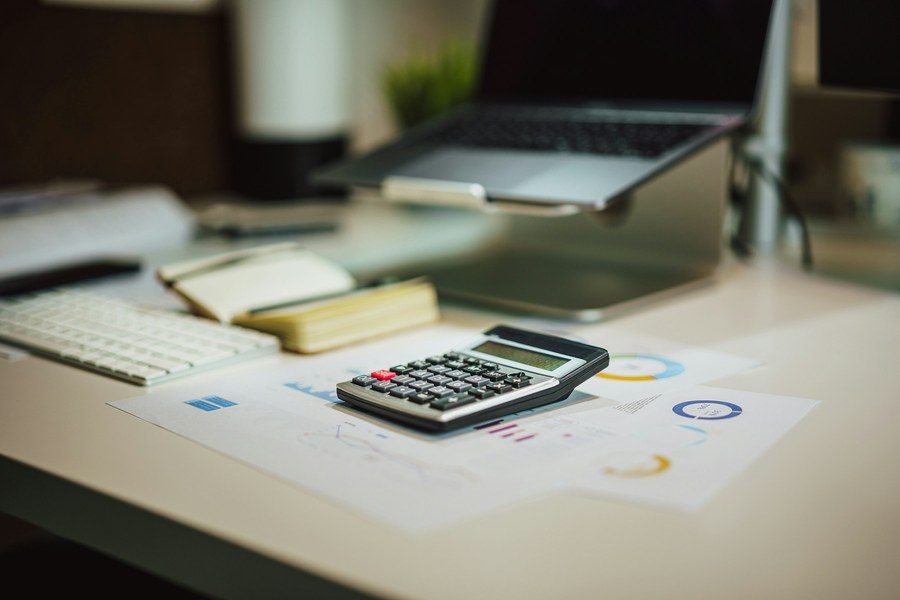 Calculadora e relatórios financeiros sobre a mesa